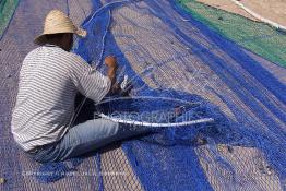 Image du Maroc Professionnelle de  Des ouvriers s'activent à réparer leurs filets de pêches au port de Laayoune, située à quelque kilomètre de la ville de Laayoune capitale du Sahara marocain, Vendredi 21 Septembre 2001. (Photo / Abdeljalil Bounhar) 